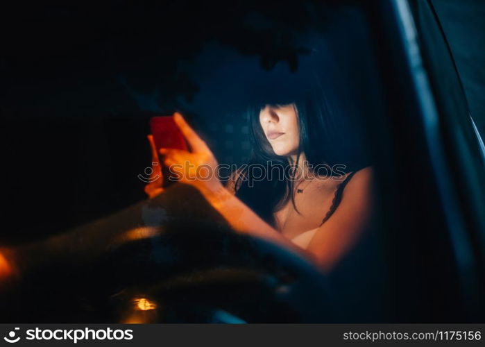 Young woman inside a car using her smartphone