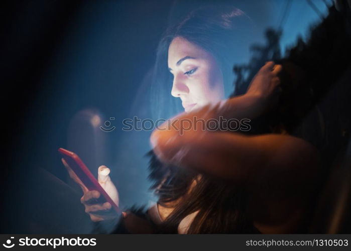 Young woman inside a car using her smartphone