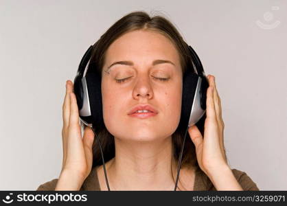 Young woman intently listening to music on headphones.