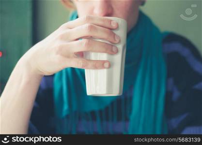 Young woman is drinking from a ceramic mug