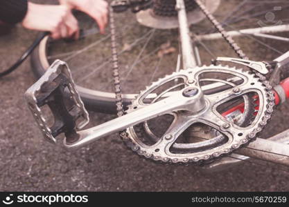 Young woman is fixing her bike and pumping her tires