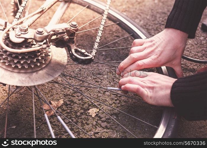 Young woman is fixing her bike and pumping her tires