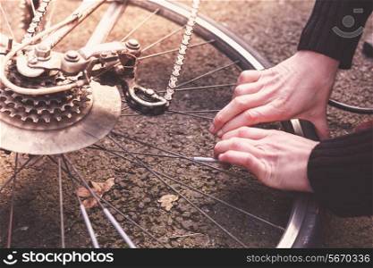 Young woman is fixing her bike and pumping her tires