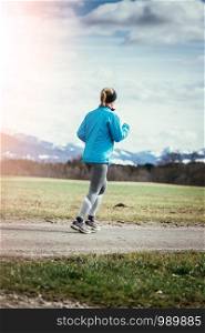 Young woman is jogging, countryside
