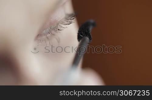 Young woman is making up her eyes.