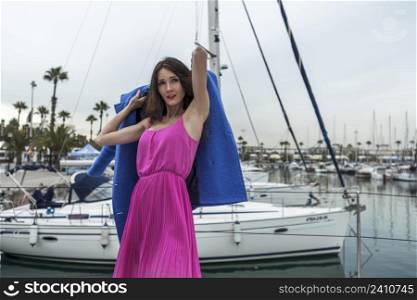 Young woman is posing on a boat at the yacht marina