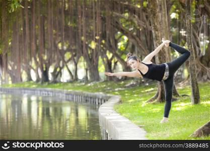 Young woman is practicing yoga at the park