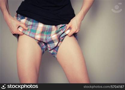 Young woman is pulling up her shorts