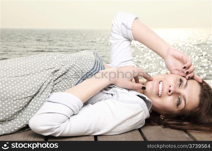 young woman is relaxing on the pier in the morning, summer holiday
