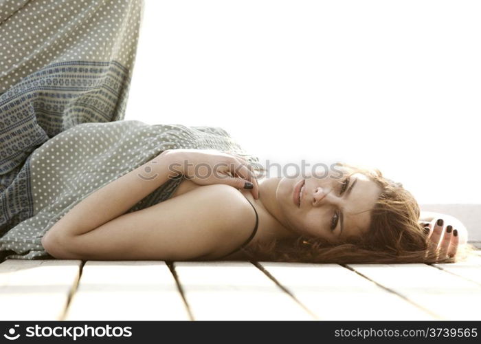 young woman is relaxing on the pier in the morning, summer holiday