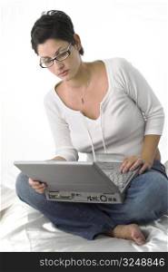 Young woman is sitting on the floor and using a notebook computer.
