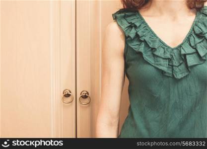 Young woman is standing next to her wardrobe