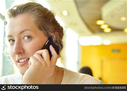 young woman is talking phone and looking at camera