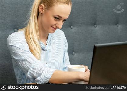 Young woman is using laptop during online learning at home office.. Woman is working on laptop at home office.