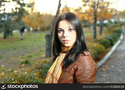 Young woman is walking outdoors in autumn alley