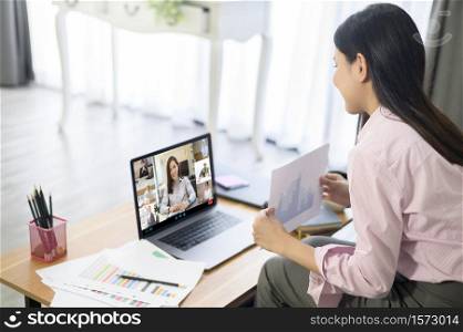 Young Woman is working with her computer screen while business meeting through video conferencing application .. Young Woman is working with her computer screen while business meeting through video conferencing application