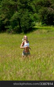 Young woman jogging in a meadow on a sunny day