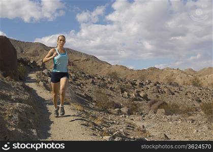 Young woman jogging in mountains