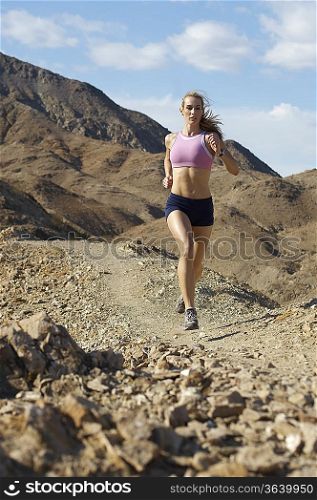 Young woman jogging in mountains