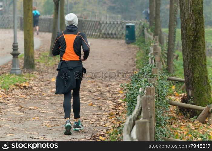 Young woman jogging in park in autumn. Health and fitness