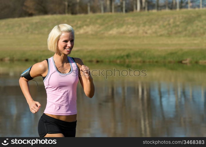 Young woman jogging recreational running by river sunny day