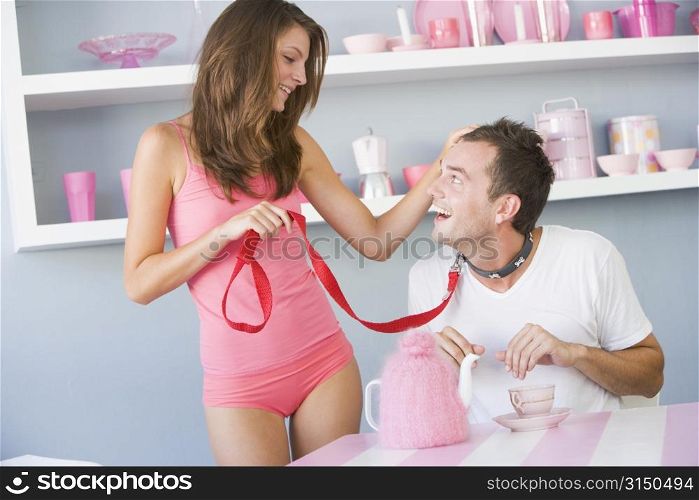 Young woman joking around with boyfriend on a leash