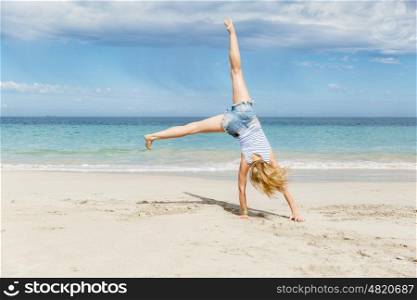 Young woman jumping on beach. Young woman having fun and jumping on beach