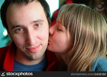 young woman kisses man
