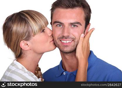 Young woman kissing a man&acute;s cheek