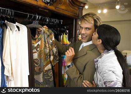 Young woman kissing a mid adult man in a clothing store