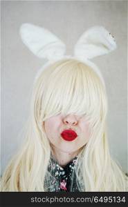 Young woman kissing and wearing bunny ears