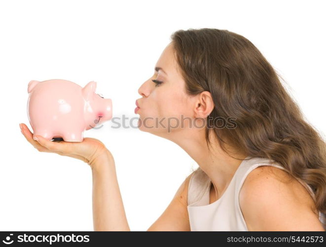 Young woman kissing piggy bank