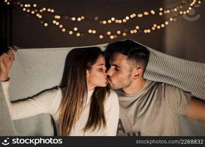 young woman kissing with man coverlet
