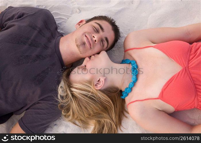 Young woman kissing young man&acute;s cheek, overhead view