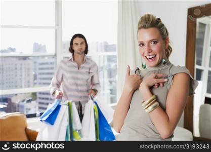 Young woman laughing with a young man holding shopping bags behind her