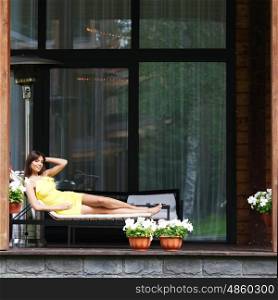 young woman laying on sunbed. young woman laying on sunbed outside the house