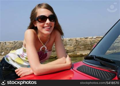 Young woman leaning against a car