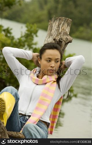 Young woman leaning against a tree stump
