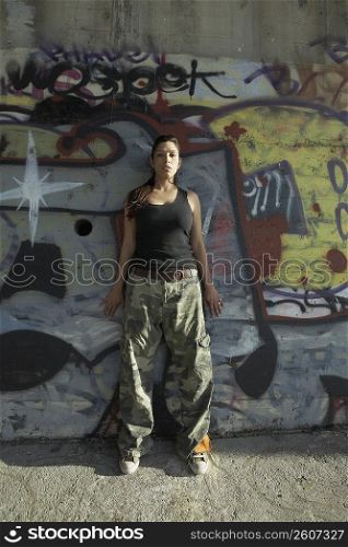 Young woman leaning against a wall