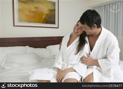 Young woman leaning on a mid adult man on the bed