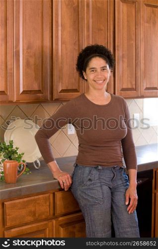 Young woman leaning on kitchen counter, portrait