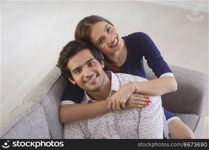 Young woman leaning over a young man from behind