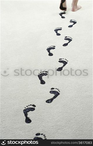 Young woman leaving black footprints on carpet