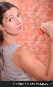 Young woman lifting dumbbell