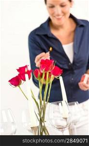 Young woman lighting candle lunch romantic love red roses