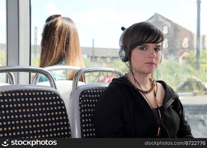 Young woman listening to her headphones on a tram
