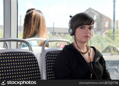 Young woman listening to her headphones on a tram