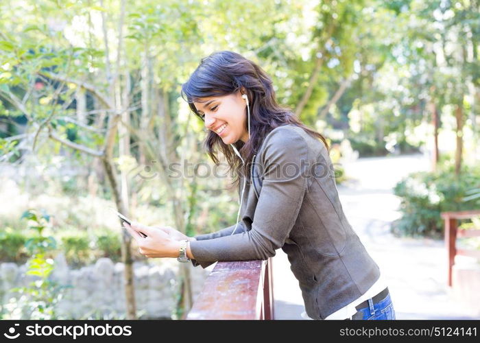 Young woman listening to music at the park