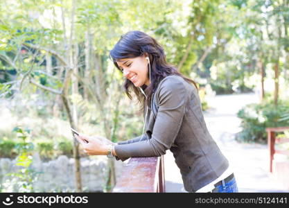 Young woman listening to music at the park