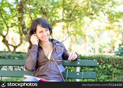 Young woman listening to music at the park